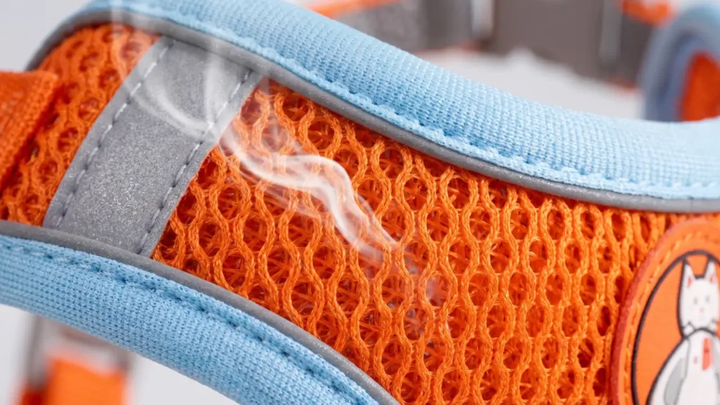 A macro close-up shot of a high-density, skin-friendly nylon fabric used in pet harnesses, highlighting its smooth, silky texture and breathable mesh lining, with soft natural lighting.